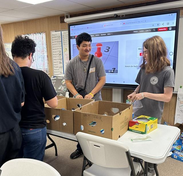 Young adults preparing food bags